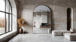 Satin Horizon Arch Mirror with matte black aluminum frame in modern minimalist living room interior