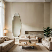 Aurora irregular curve mirror displayed in a modern living room interior with sofa and coffee table.