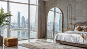 Grand Arcadian Mirror with brushed gold arched frame in modern bedroom reflecting city skyline